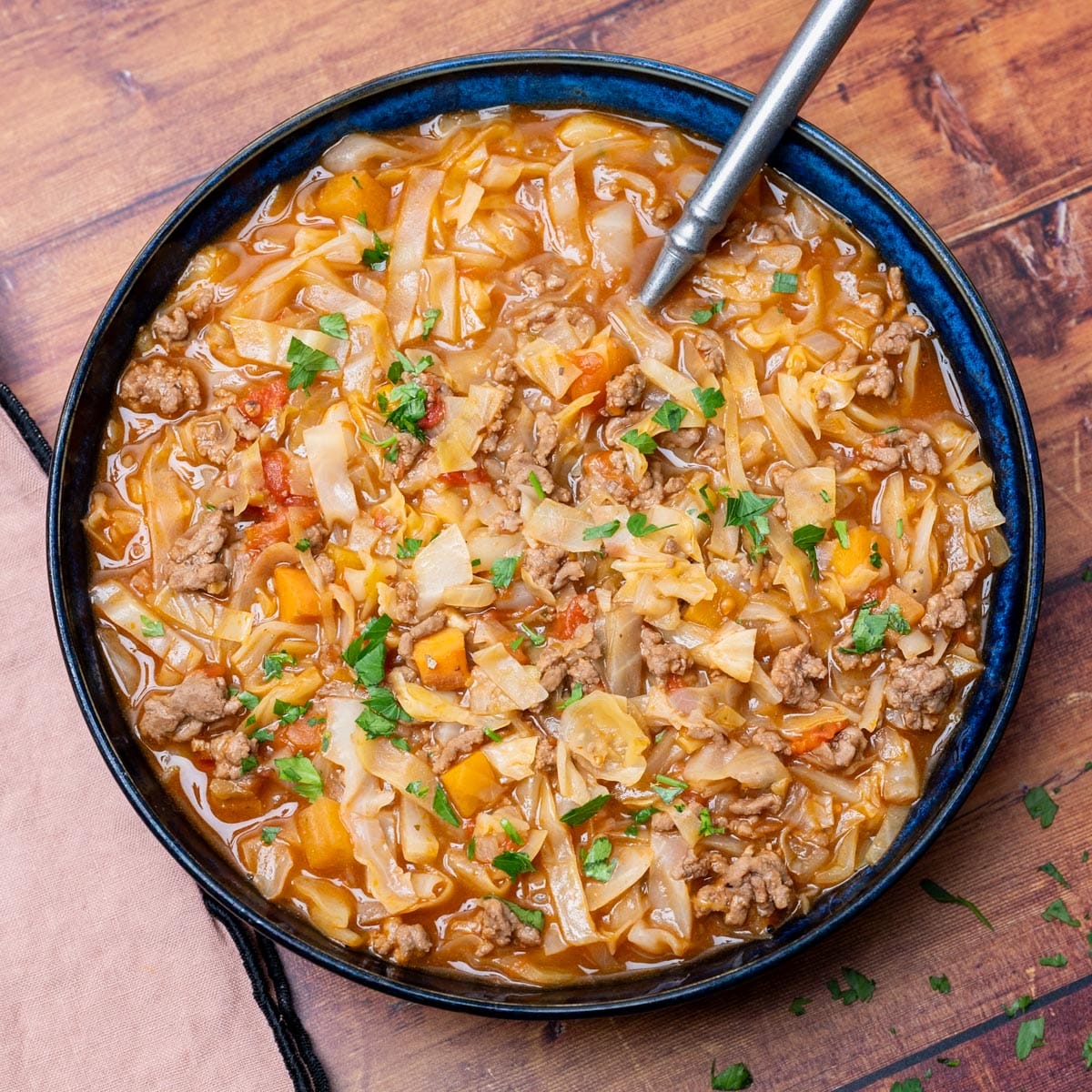 blue bowl with ground meat, carrots and parsley on top