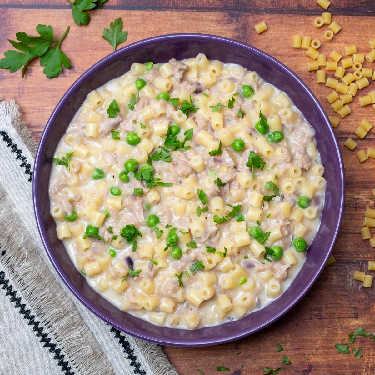 a purple bowl with pasta and peas